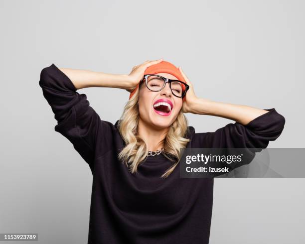 young woman laughing with hands in head - hipster fun stock pictures, royalty-free photos & images