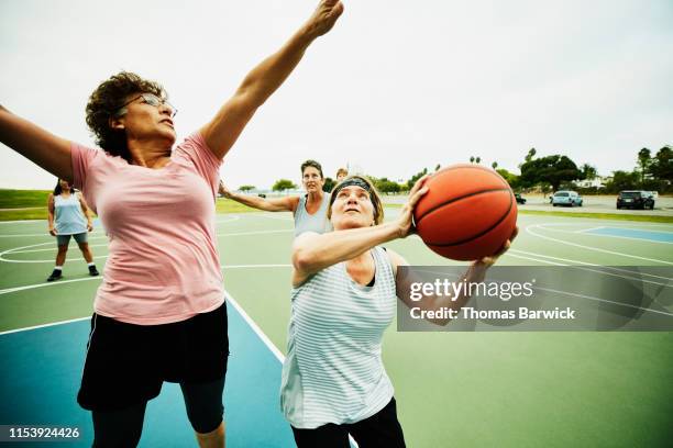 mature woman waiting to take shot during basketball game on outdoor court - taking a shot - sport imagens e fotografias de stock