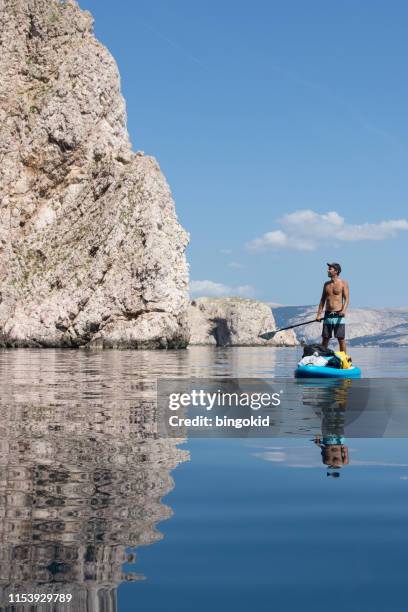 man stand up paddling under the cliffs - using a paddle stock pictures, royalty-free photos & images