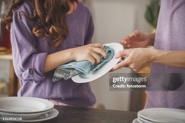 chica ayudando a la madre limpiando los platos en la cocina - dish fotografías e imágenes de stock