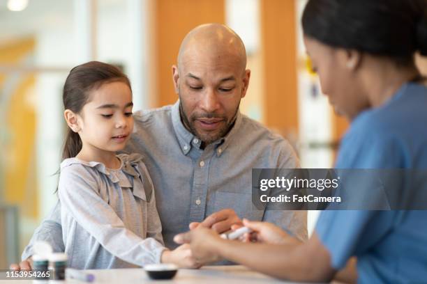 vader holding jonge dochter op een doktersafspraak - allergy doctor stockfoto's en -beelden