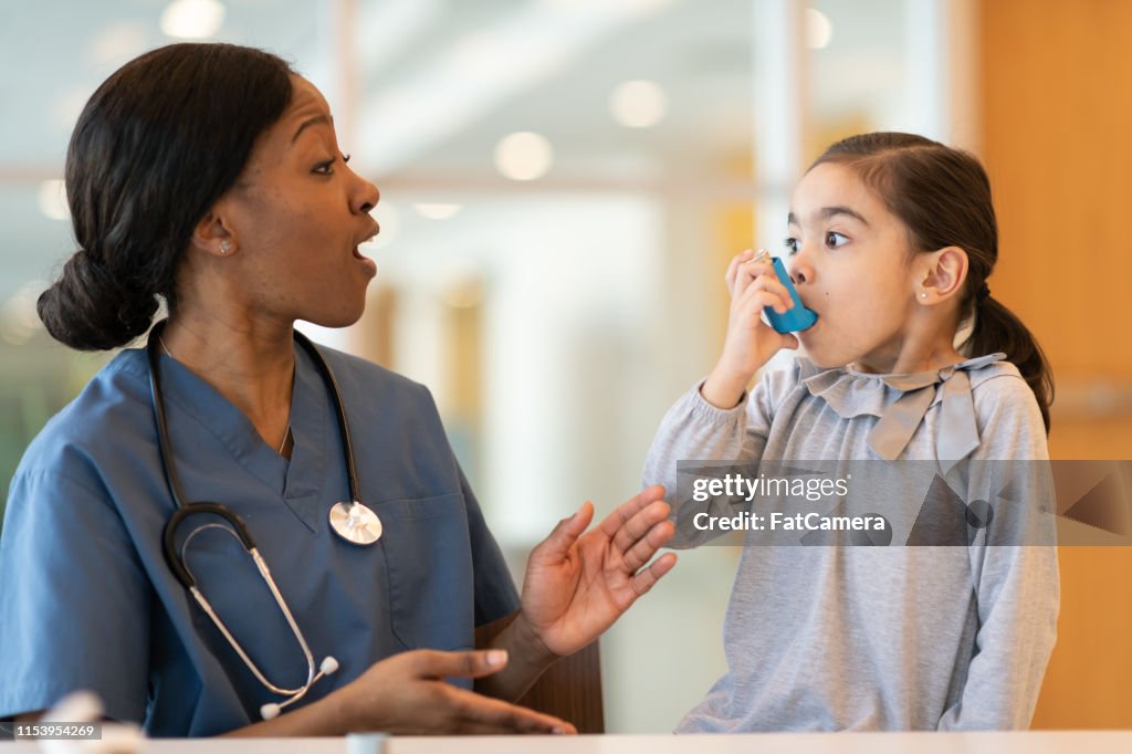 El médico femenino asiste al paciente asmático joven