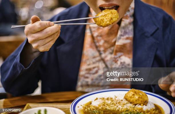 woman eating croquette curry in restaurant - カレー　日本 ストックフォトと画像