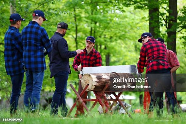 Pierre Gasly of France and Red Bull Racing and Max Verstappen of Netherlands and Red Bull Racing saw a log at the Red Bull lumberjack challenge...