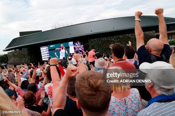 Spectators on Murray Mount cheer as they watch a big screen showing US player Cori Gauff winning the second set against Slovenia's Polona Hercog...