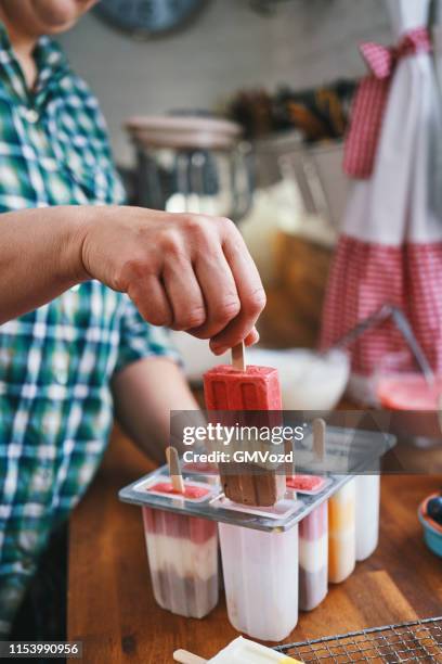 preparing mango, strawberry, chocolate, yogurt ice cream on stick - making popsicles stock pictures, royalty-free photos & images