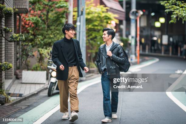 東京で歩いて話をする日本の男性の友達をのんびり - メンズファッション ストックフォトと画像