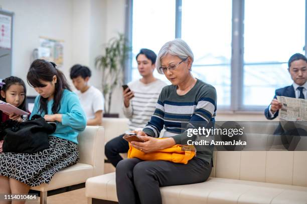 japanse patiënten zitten in een medische kliniek wachtkamer - hospital waiting room stockfoto's en -beelden