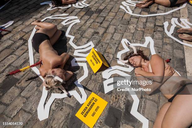 Two activists against animal cruelty lie on the ground like dead bodies inside chalk outlines of bulls during a performance against bullfightings...