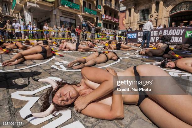 Activists against animal cruelty lie on the ground like dead bodies inside chalk outlines of bulls during a performance against bullfightings before...