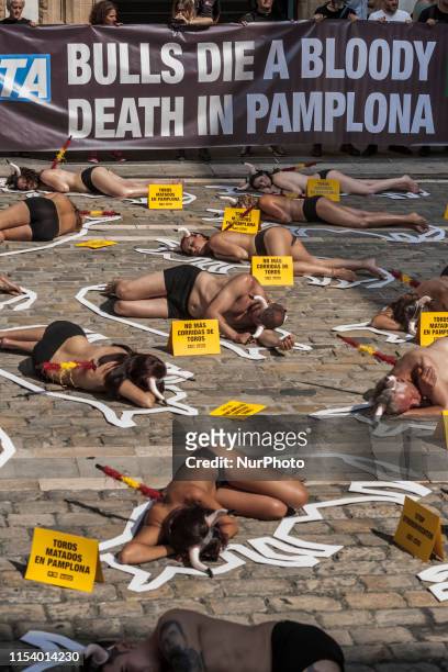 Activists against animal cruelty in bullfightings, lie on the ground like dead bodies inside chalk outlines of bulls during a protest performance...
