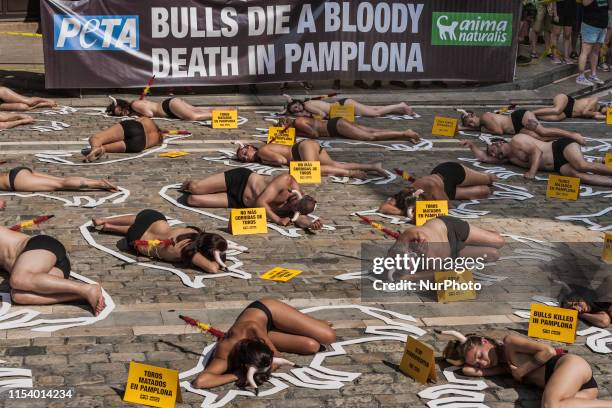 Nude activists against animal cruelty in bullfightings, lie on the ground like dead bodies inside chalk outlines of bulls during a protest...