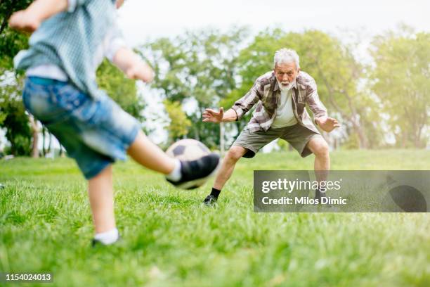 grootvader en kleinzoon geniet van een spelletje - ball pit stockfoto's en -beelden