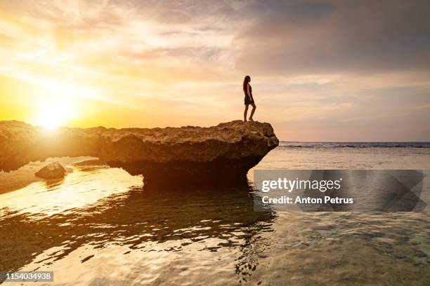 beautiful girl in dress on the rocky beach at sunset. red sea. - marsa alam stock pictures, royalty-free photos & images