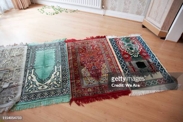 prayer mats on floor of living room - prayer mat stock-fotos und bilder