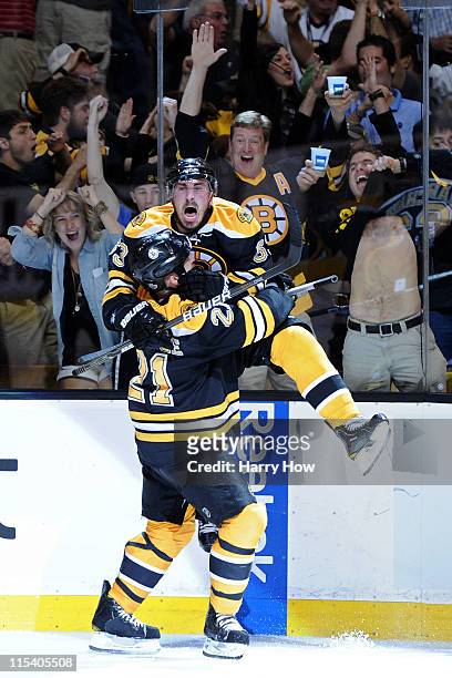 Brad Marchand of the Boston Bruins celebrates with teammate Andrew Ference after scoring a goal in the second period against Roberto Luongo of the...