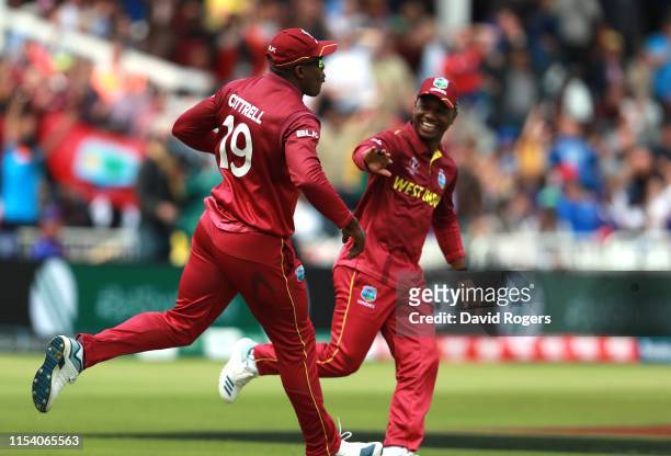 Sheldon Cottrell of the West Indies celebrates with team mate Evin Lewis after catching out Steve Smith during the Group Stage match of the ICC...