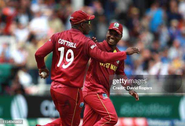 Sheldon Cottrell of the West Indies celebrates with team mate Evin Lewis after catching out Steve Smith during the Group Stage match of the ICC...