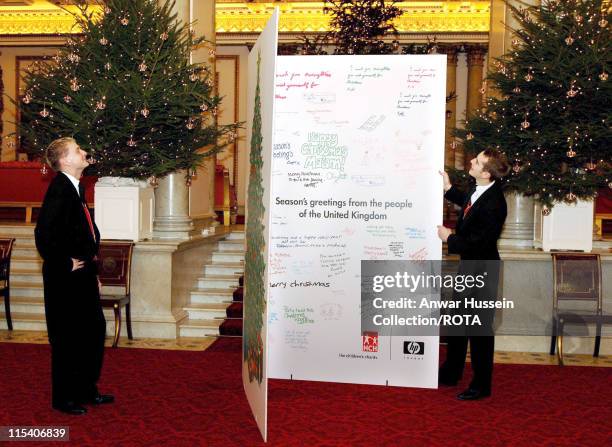 Royal footmen stand with a giant Christmas card to the Queen in the Marble Hall at Buckingham Palace in London, December 15, 2005. The card bears an...