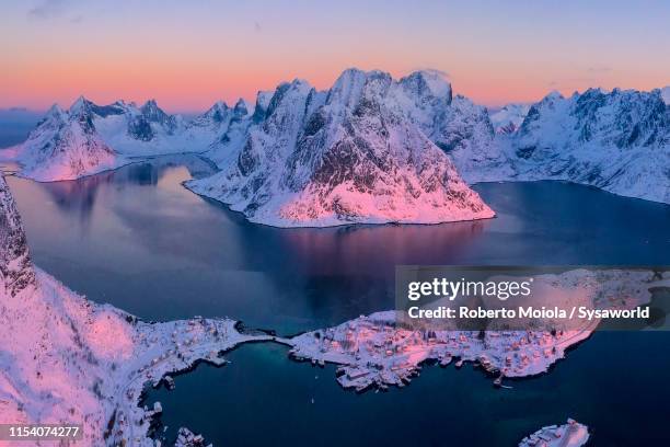 aerial view of snowy fjord and reine at sunrise, norway - bergen norway stock-fotos und bilder