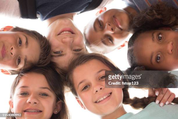 multi-ethnic group of school children friends in huddle. - mixed age range stock pictures, royalty-free photos & images