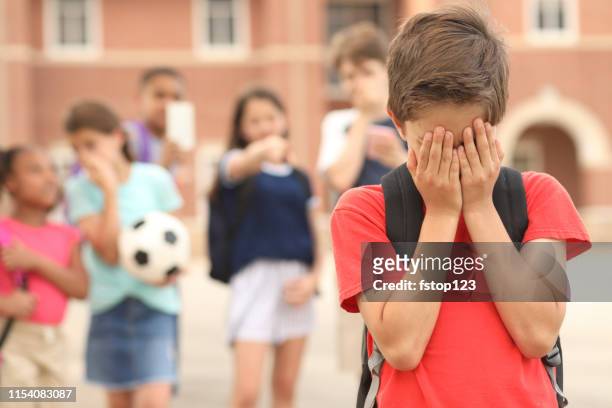 elementary age boy being bullied at school. - social exclusion stock pictures, royalty-free photos & images