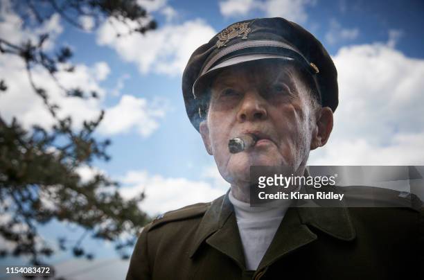 World War II veteran Dennis Thompson , who flew his 6th bombing mission on D-Day in a B24 Bomber, enjoys a celebratory cigar in his original uniform...