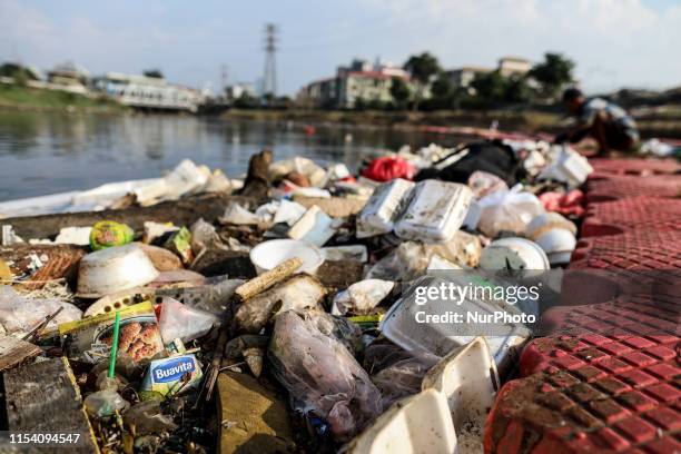 Man collects plastic goods in the Ciliwung river littered with garbage in Jakarta, Indonesia on July 6, 2019.