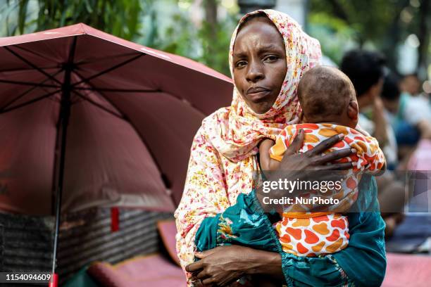 Sudanese migrant woman with her baby is seen next to a tent near Jakarta's UNHCR headquarters to protest their resettlement delays in Jakarta,...