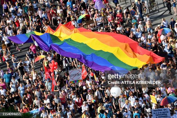 People march with their giant rainbow flag from the parliament building in Budapest downtown during the lesbian, gay, bisexual and transgender Pride...