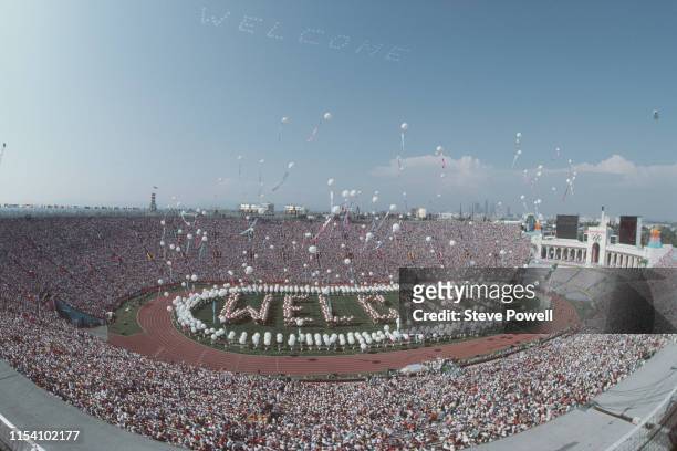 Performers spell out Welcome on the stadium infield as balloons are released above them during the opening ceremony for the XXIII Olympic Games on 28...