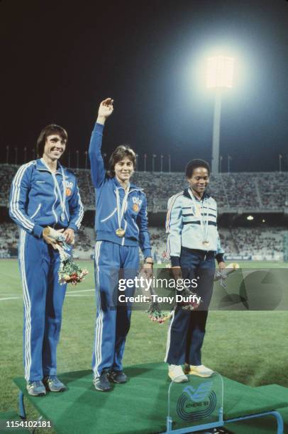 Marlies Gohr of East Germany celebrates her gold medal with second placed compatriot Barbel Wockel and third placed Rose-Aimee Bacoul of France after...