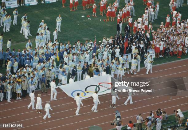 The Olympic flag is carried by former United States medalists led by Bruce Jenner, Wyomia Tyus, Parry O'Brien, Al Oerter, Billy Mills, John Naber,...