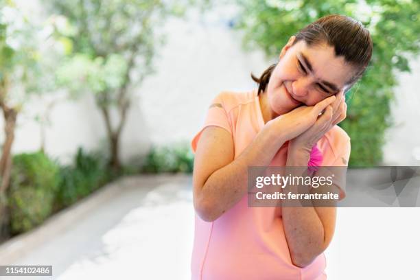 portrait of a woman with down syndrome hugging self - mental disability stock pictures, royalty-free photos & images