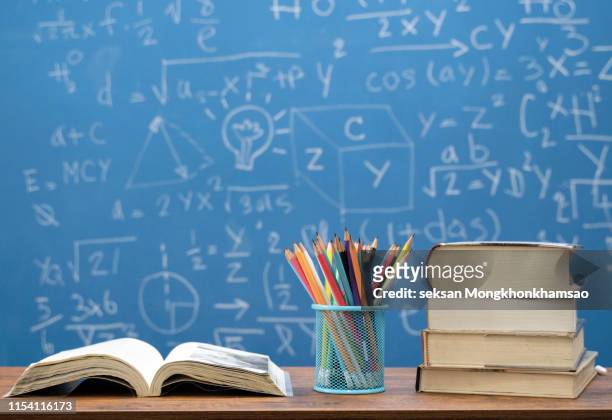 back to school supplies. books and blackboard on wooden background - teacher desk stock pictures, royalty-free photos & images