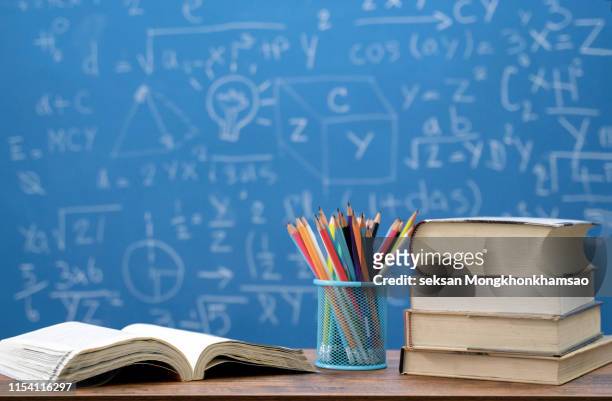 back to school supplies. books and blackboard on wooden background - physics chalkboard stock pictures, royalty-free photos & images