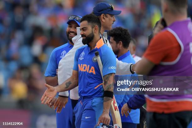 India's Rohit Sharma, India's captain Virat Kohli and India's head coach Ravi Shastri on the pitch after their victory in the 2019 Cricket World Cup...