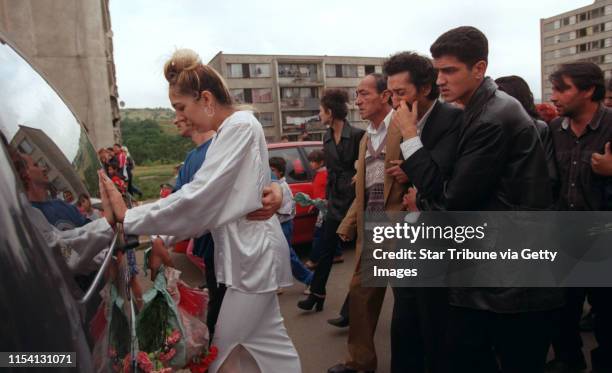 Chanov, Czech Republic. July 9, 1999. Roma Funeral. -- The fiancee of the deceased man, in white, and Karel Fedacova, the father of the deceased,...