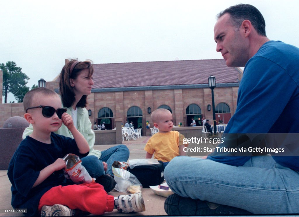 Rededication of Harriet Island Regional Park. -- Dennis and Kris Curoe and their sons Brad, 3, (with sunglasses) and Joel, 1-1/2, celebrated the occasion with a picnic on the Great Stairs outside the pavillion as speeches were given inside. They are among
