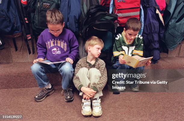 Michael Metcalf listens as his 2nd grade classmates Carl Iverson left and David Baker read a book about Peter rabbit. Michael has battens disease and...