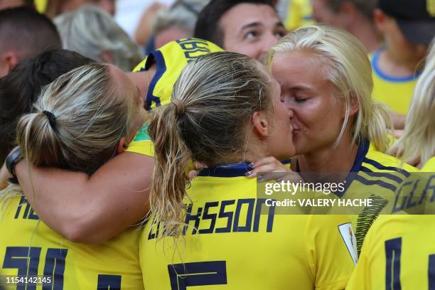Sweden's defender Magdalena Eriksson kisses her girlfriend Danish international Pernille Harder as she celebrates her team's victory at the end of...
