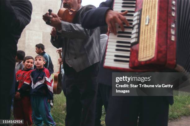 Chanov, Czech Republic. July 9, 1999. Roma Funeral. -- Roma children listen to the tunes of a band that played for the funeral of a 21-year-old man.