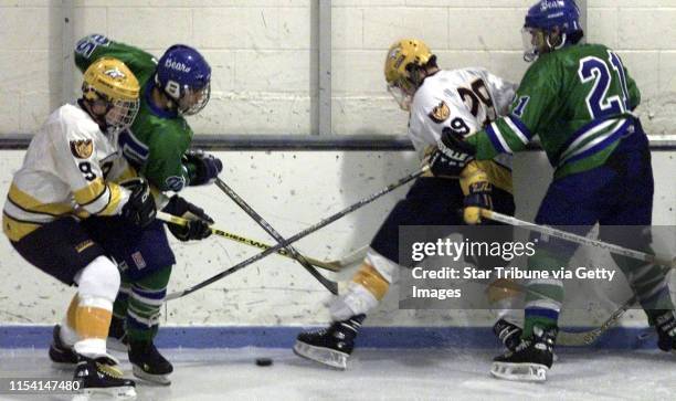 The Breck and Breck hockey team members mix it up in attempting to control the puck in first period action. From left to right is Breck Colin Hohman;...