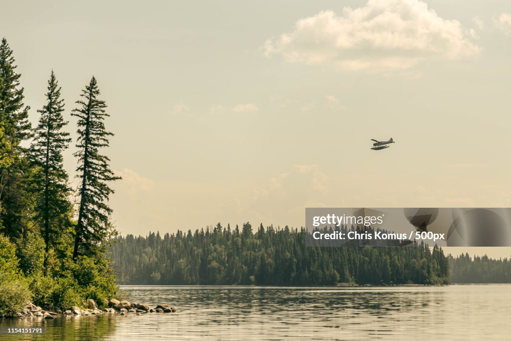 Island Lake, Manitoba With Float Plane In The Sky