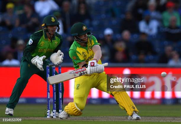Australia's David Warner attempts a reverse sweep shot as South Africa's wicketkeeper Quinton de Kock looks on during the 2019 Cricket World Cup...