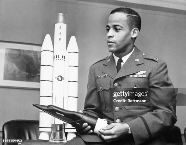 Captain Edward J. Dwight, Jr., the first African American selected as a potential astronaut, looks over a model of the Titan III-X-20 Dyna-Soar...