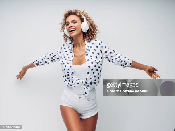 portret van vrolijke positieve meisje met een koptelefoon op haar hoofdluis teren muziek en dans - dj summer stockfoto's en -beelden