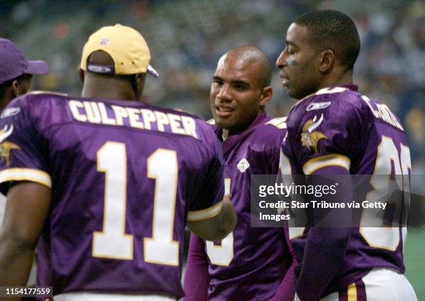 San Antonio, TX - Former Gopher and current Viking quarterback Billy Cockerham, center, gets advice from quarterback Dante Culpepper, left, and wide...