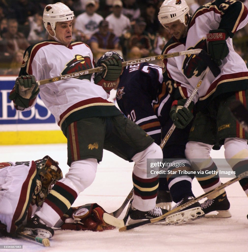 SUNDAY_04/14/02_St.Paul - - - - With Wild goalie #30 Dwayne Roloson (bottom left) on top of the puck, #2 Willie Mitchell going over backwards, #33 Sergei Zholtok and Oiler#20 Jochen Hecht mix it up for control of the puck. (end of 3rd period)