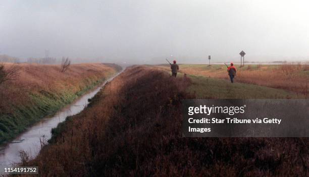 Benson, Mn., Sat., Oct. 13, 2001--Fog envelops hunters as the 2001 Minnesota pheasant season opens. IN THIS PHOTO: Through the wet grass and early...